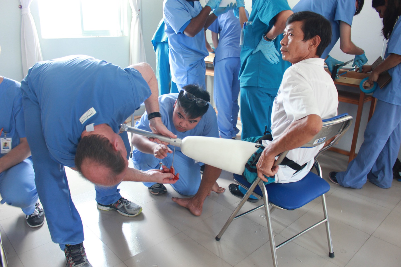 Dr. McMahan attending to man with prosthetic leg