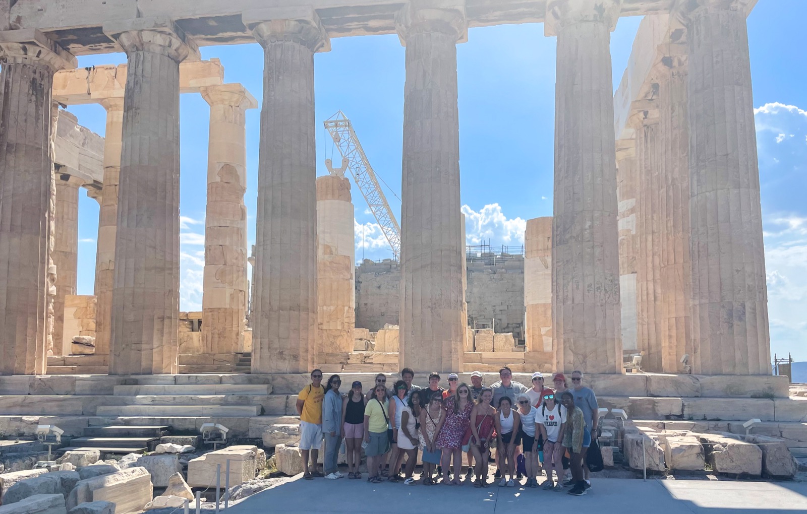 A group of people in front of greek ruins