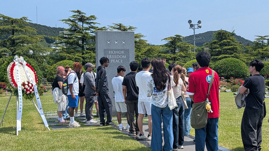 Students standing at a memorial