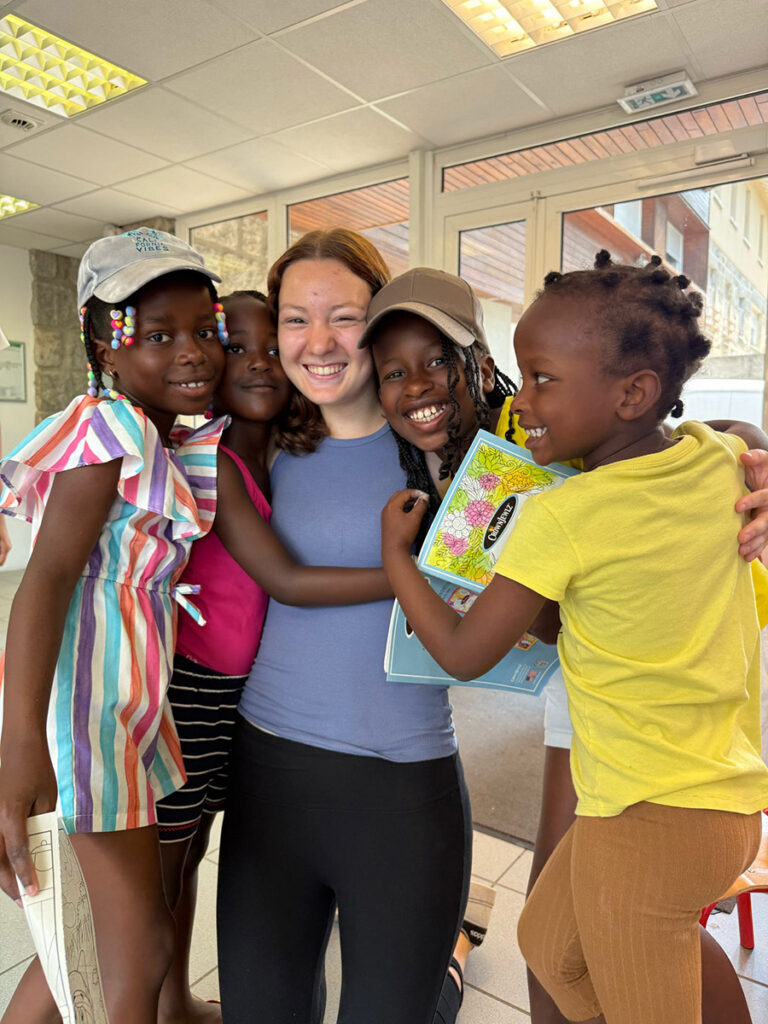 Student hugging children