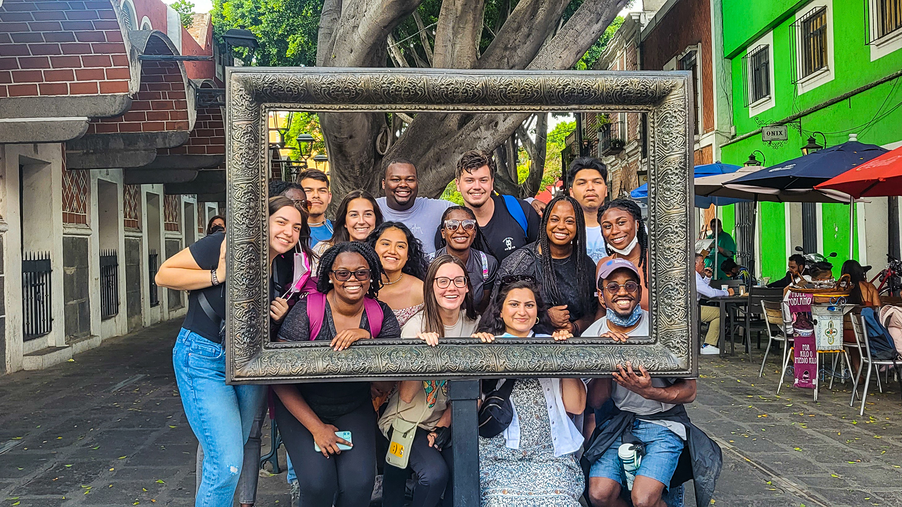A group of students posing inside a "frame" for a photo.