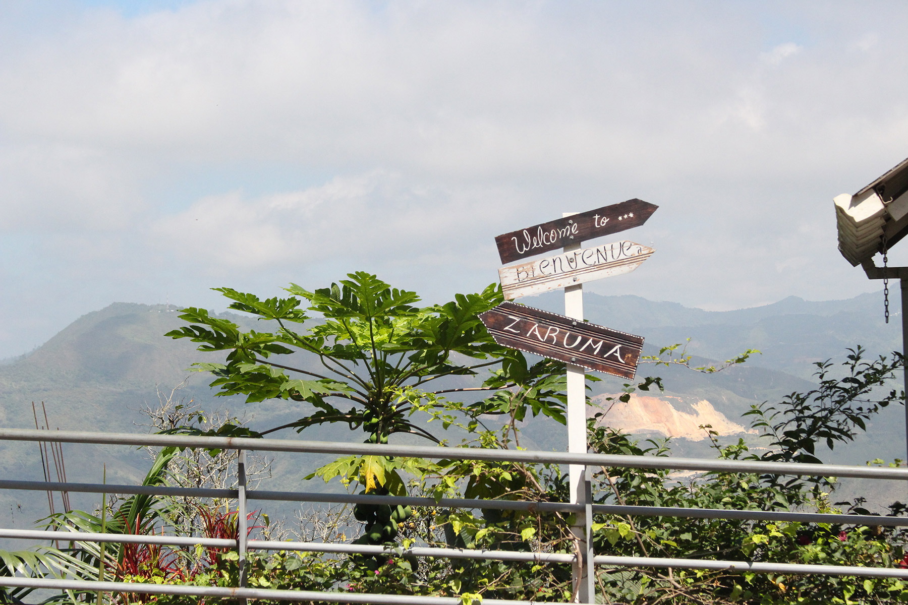 A landscape in Ecuador with a "Welcome to Zaruma" sign in the foreground