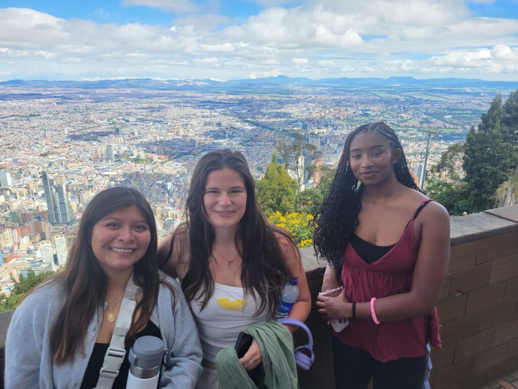 Three students pose for a photo at an overlook
