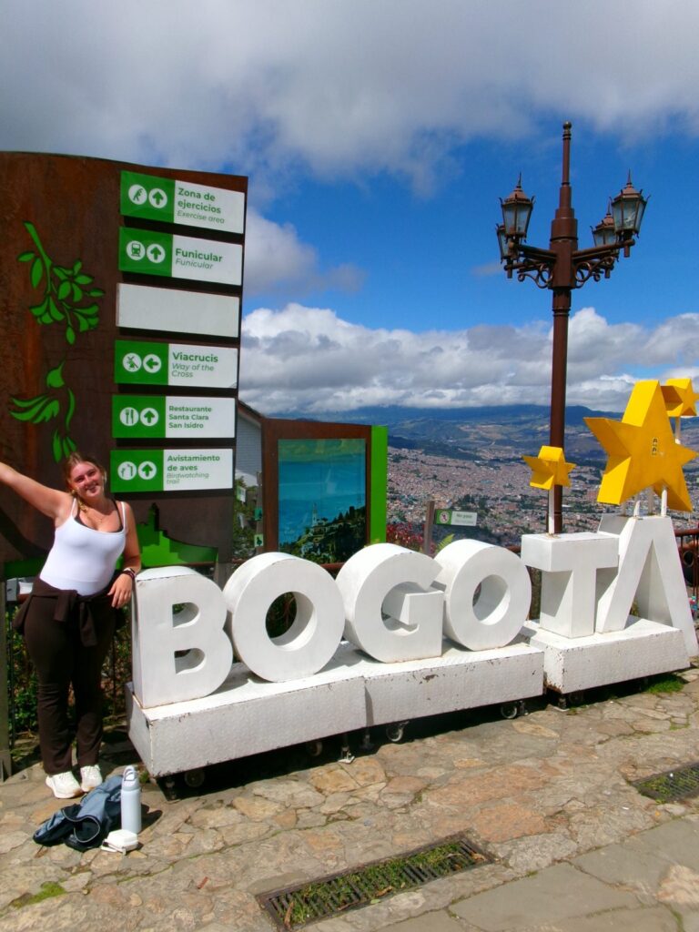 A Mercer student posing by a Bogota sign