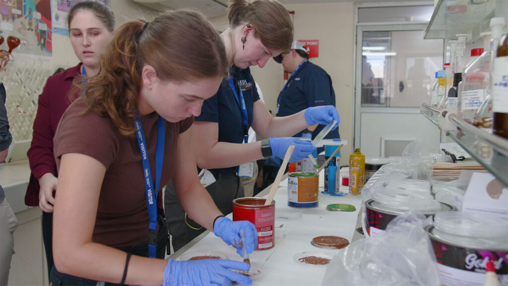 Students testing paint in a lab